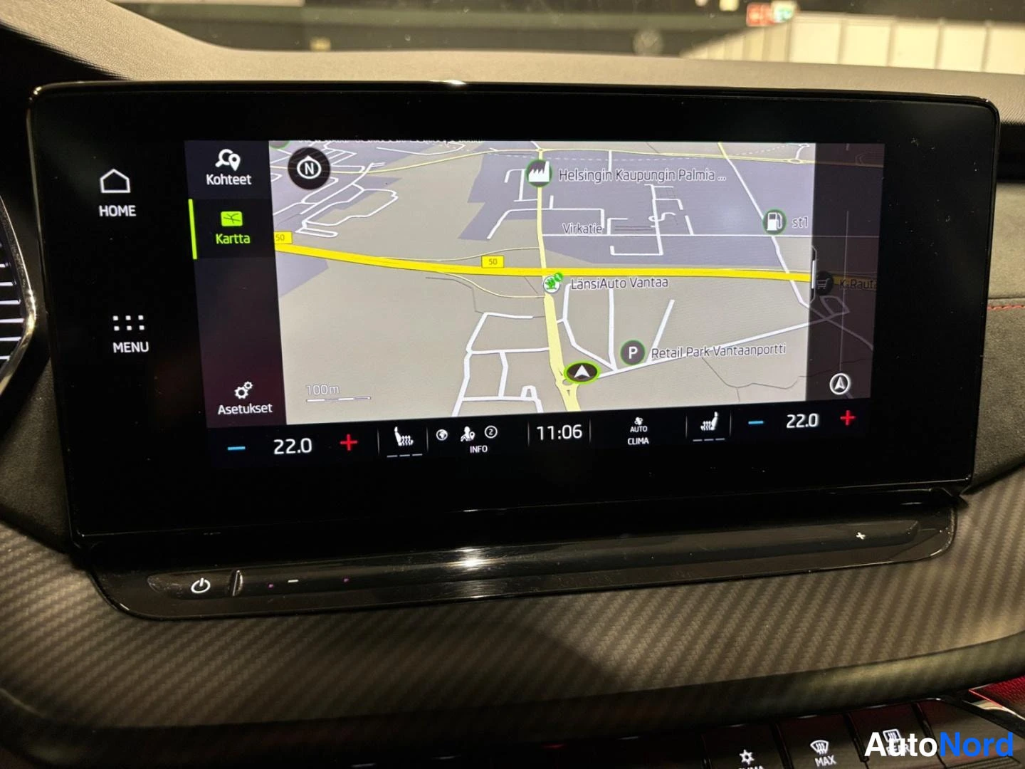 Yksityiskohta: Keskikonsolin suuri näyttö näyttää karttaa ja ilmastointiasetuksia (Auto Clima 22,0)
