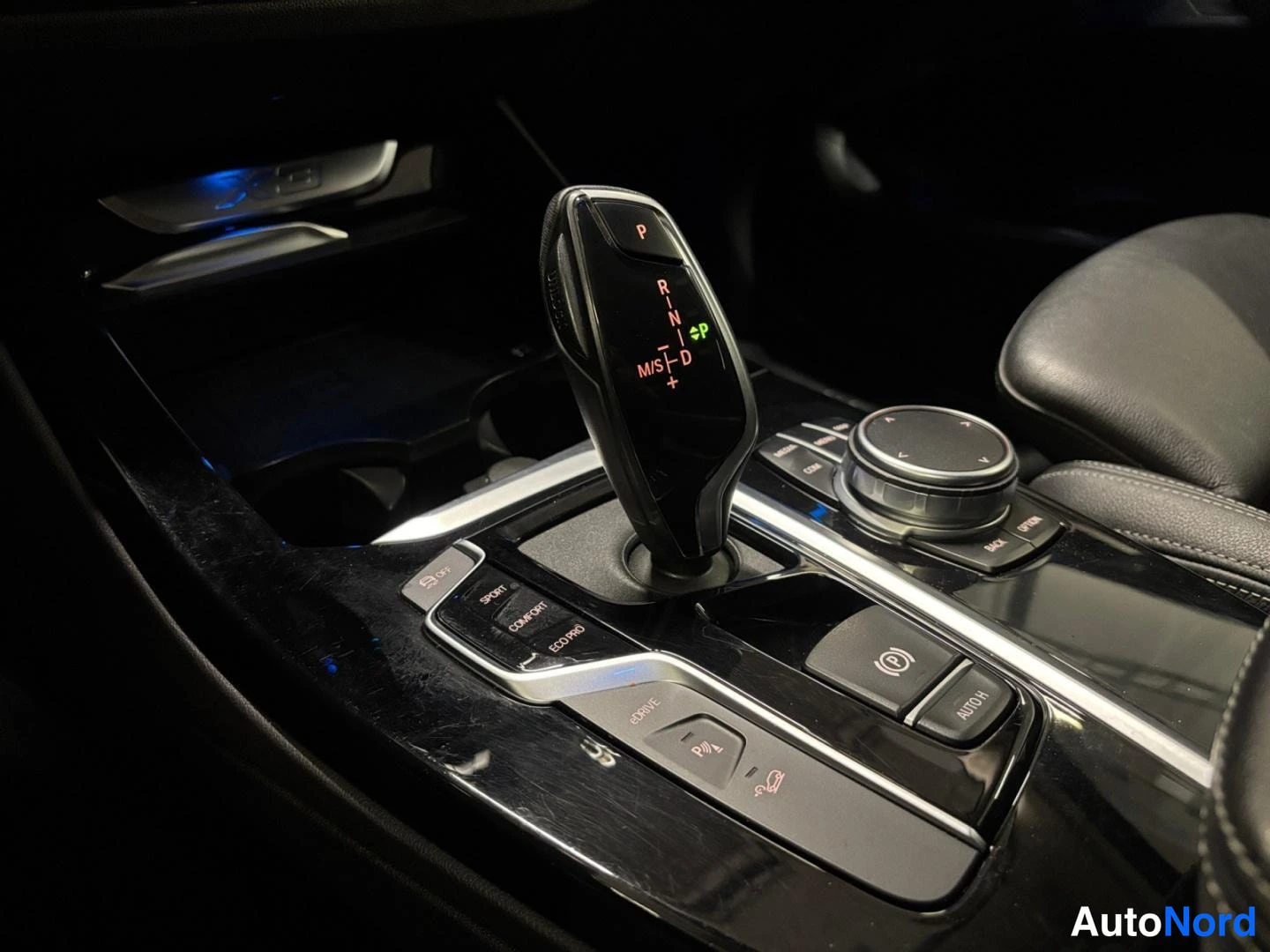 Yksityiskohta: Automaattivaihteen valitsin ja iDrive-ohjain keskikonsolissa, painikkeet SPORT, COMFORT ja ECO PRO