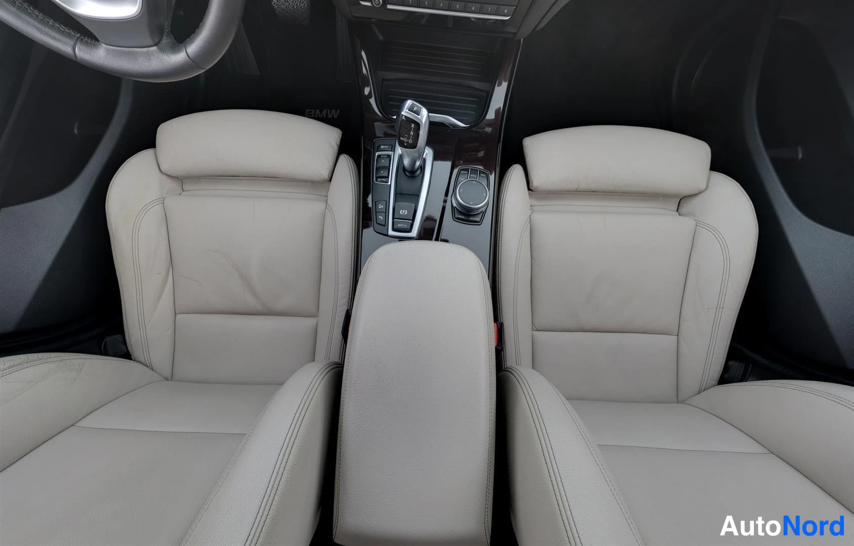 Etuistuimet: BMW:n etupenkit vaaleanpuna-beige-sävyisenä nahkaverhoiluna ja automaattivaihteen valitsin keskikonsolissa.