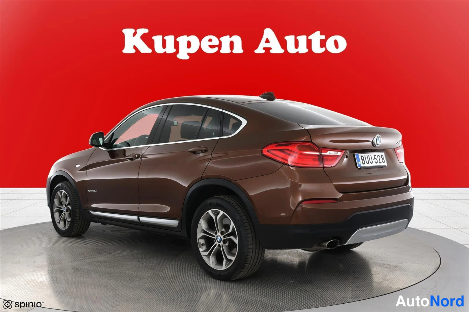 Takaviisto: Ruskean BMW X4:n takakulmakuva, punainen tausta, rekisteritunnus.