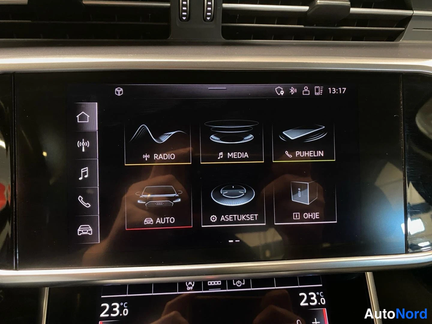 Yksityiskohta: Audi A6:n infotainment-näytön päävalikko: Radio, Media, Puhelin, Auto, Asetukset, Ohje