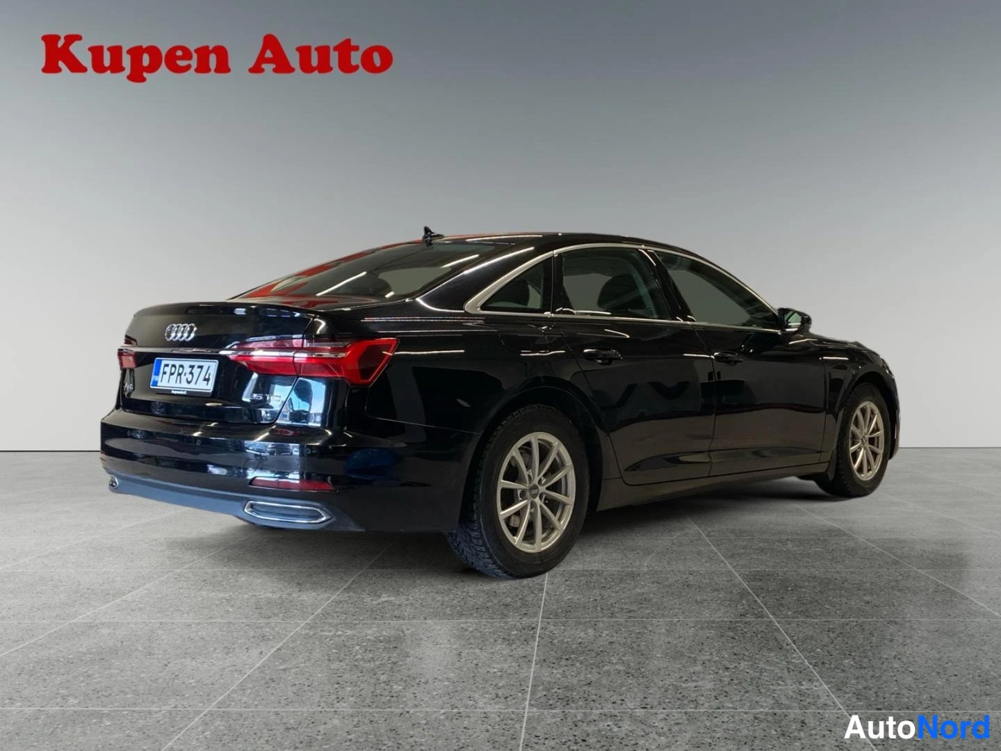Takaviisto: Mustan Audi A6 -sedanin takakulmanäky vasemmalta, rekisterikilpi.
