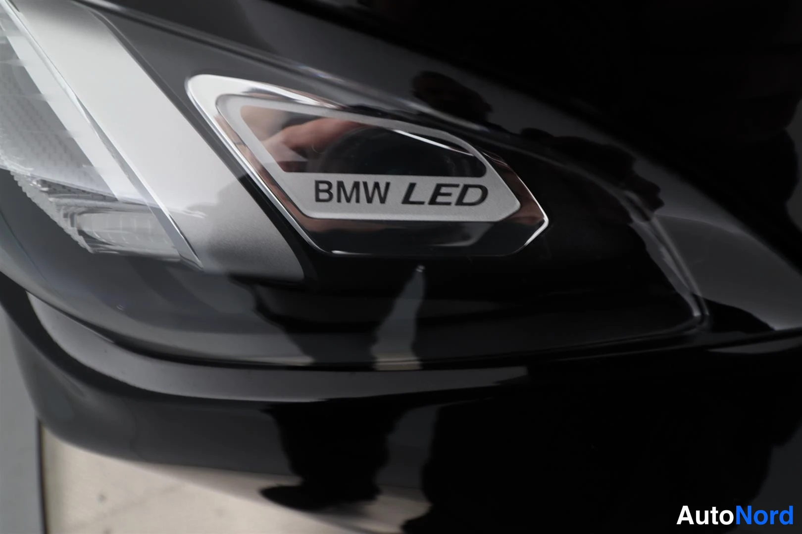 Yksityiskohta: Musta BMW-ajoneuvon etusarvi, etulyhtymässä lukee 'BMW LED'.