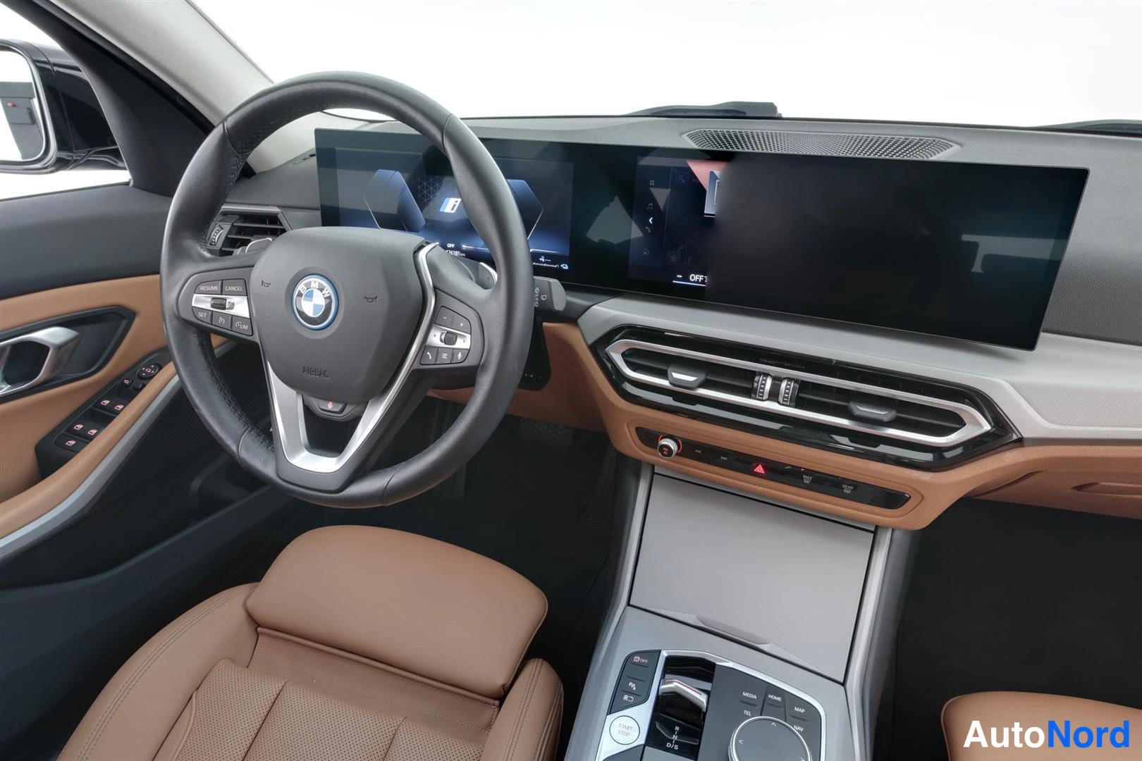 Muu: Ohjaamo vasemmalta: BMW-ohjauspyörä, kaareva laaja näyttö kojelaudassa ja ruskeat nahkaistuimet.