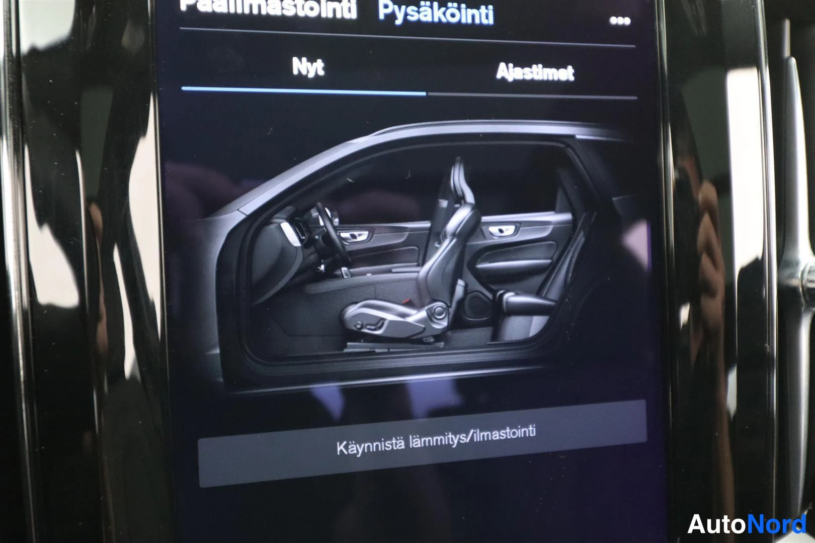 Yksityiskohta: Keskusnäytön esilämmitys/ilmastointi -valikko tekstillä Pääilmastointi, Pysäköinti, Käynnistä lämmitys/ilmastointi.