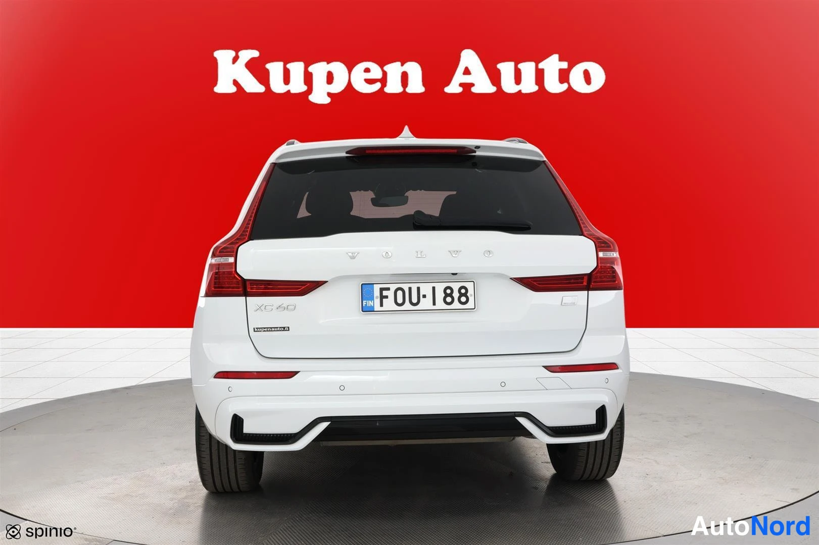 Takaa: Valkoinen Volvo XC60 suoraan takaa, rekisterikilpi, punainen tausta.