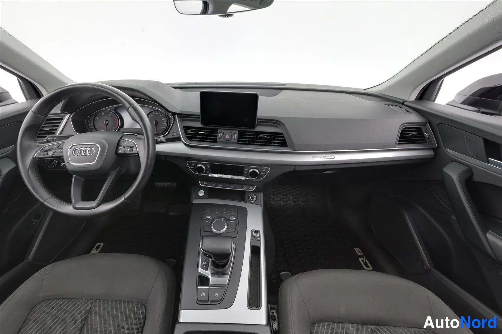 Ohjaamo: Audi Q5:n matkustamo etupuolelta: Audi-ohjauspyörä, kojetaulu, keskinäyttö ja automaattivaihteen valitsin.
