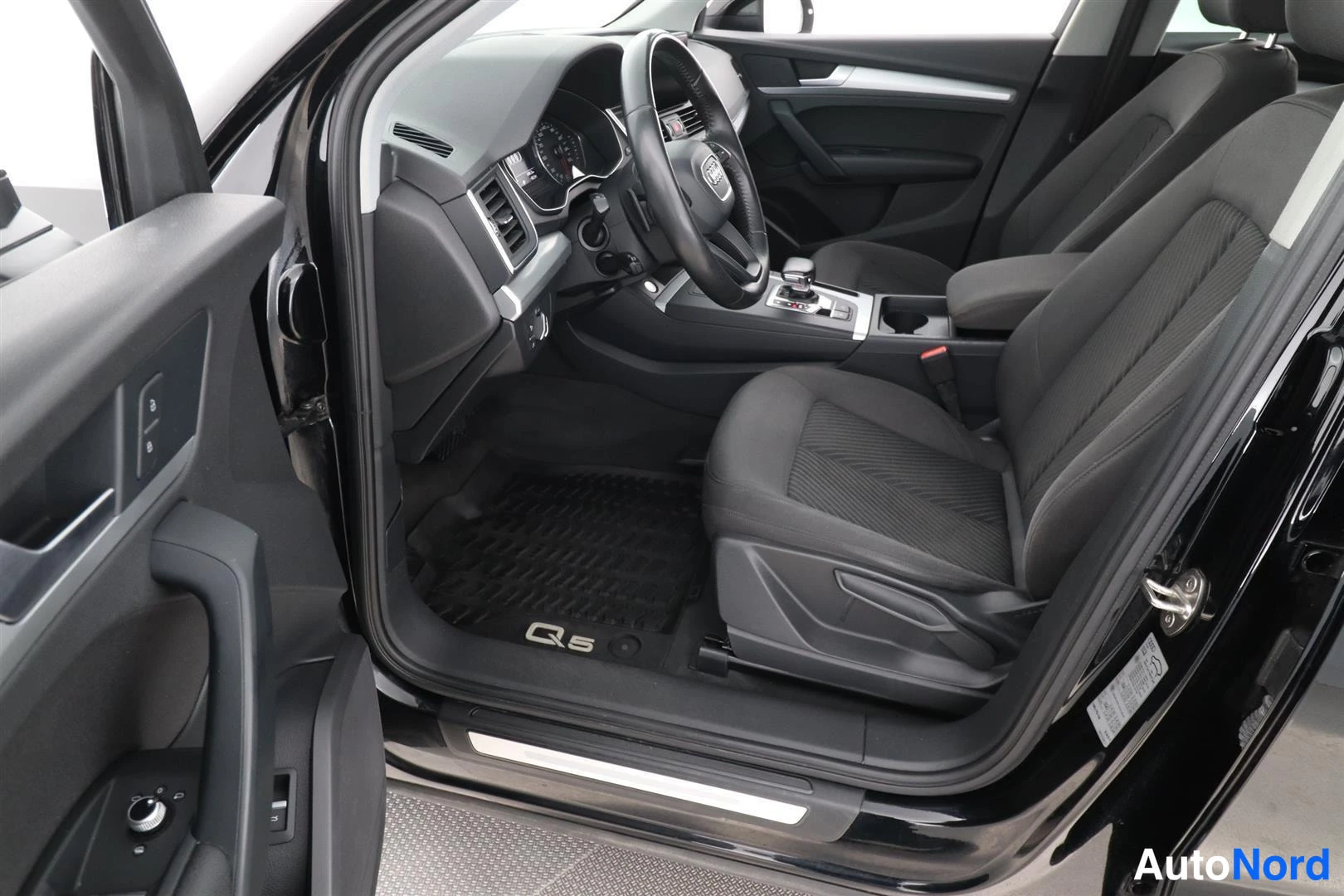 Ohjaamo: Audi Q5:n etuistuimet ja kojelauta kuljettajan ovesta kuvattuna.