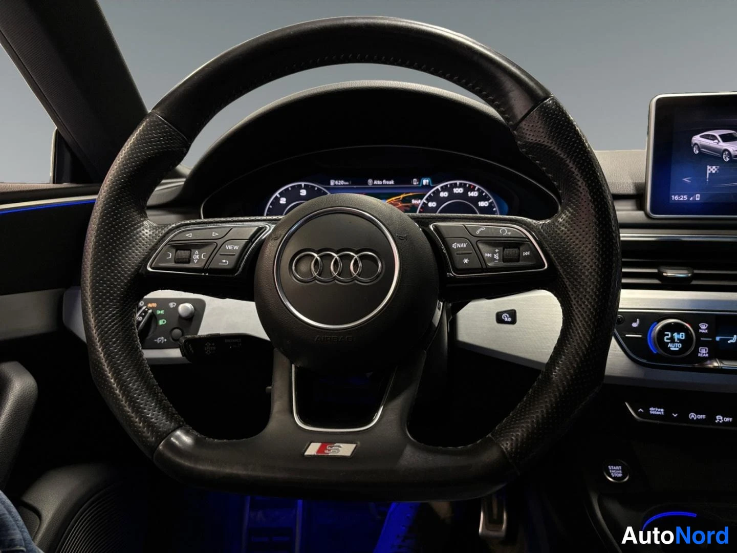 Muu: Ohjauspyörä Audi-logolla ja S-merkinnällä, digitaalinen mittaristo ja keskinäyttö näkyvät taustalla.