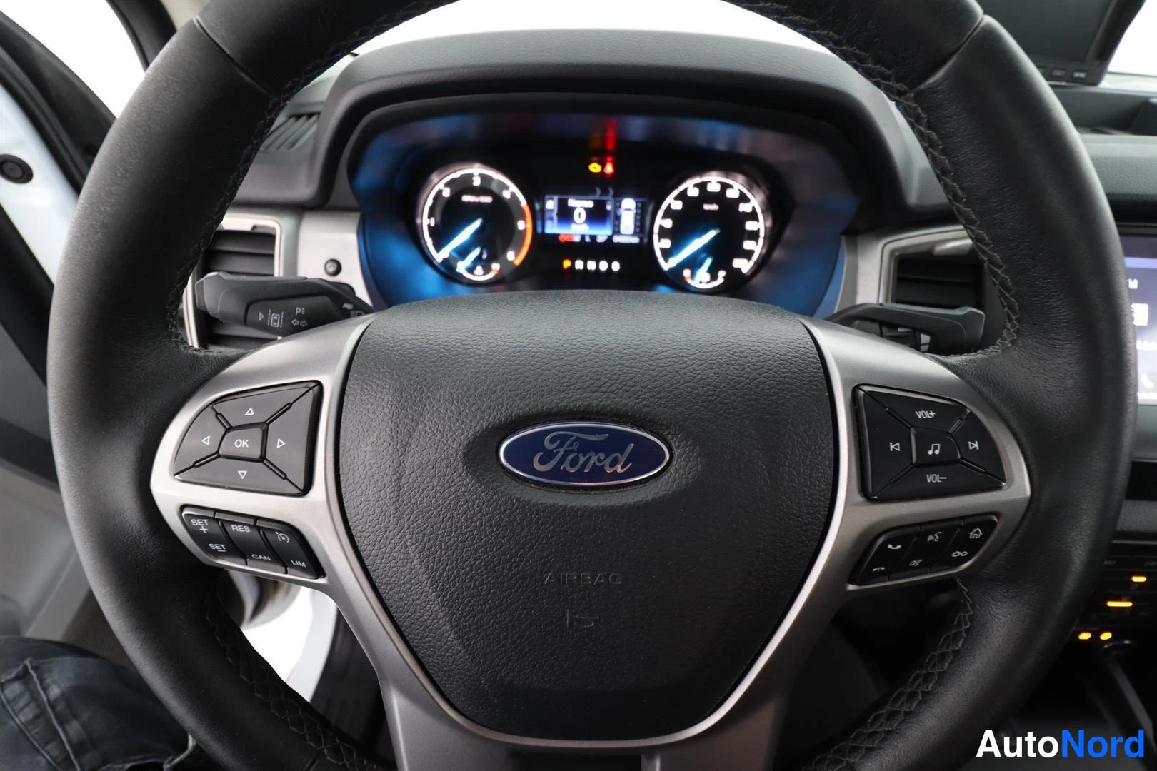 Muu: Ohjauspyörä Ford-merkillä ja mittariston näkymä kuljettajan puolelta.
