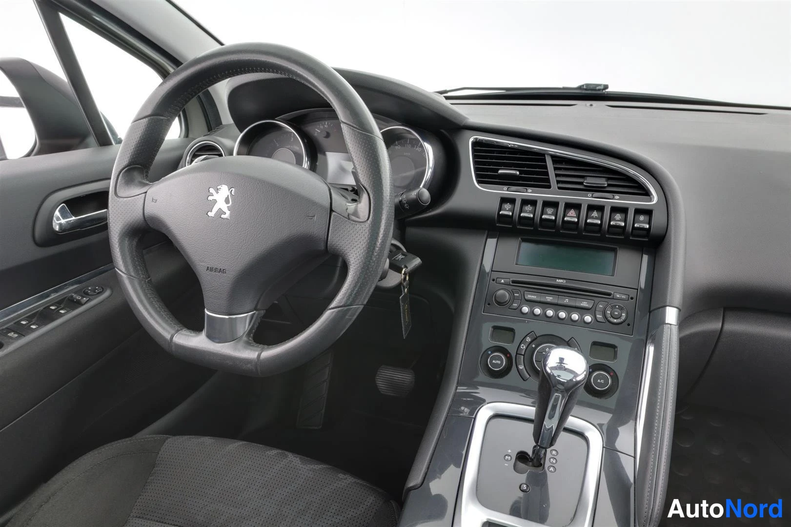 Muu: Kuljettajan puolen sisätilat: Peugeot-merkitty ohjauspyörä, mittaristo, äänentoistopaneeli ja automaattivaihteen valitsin.