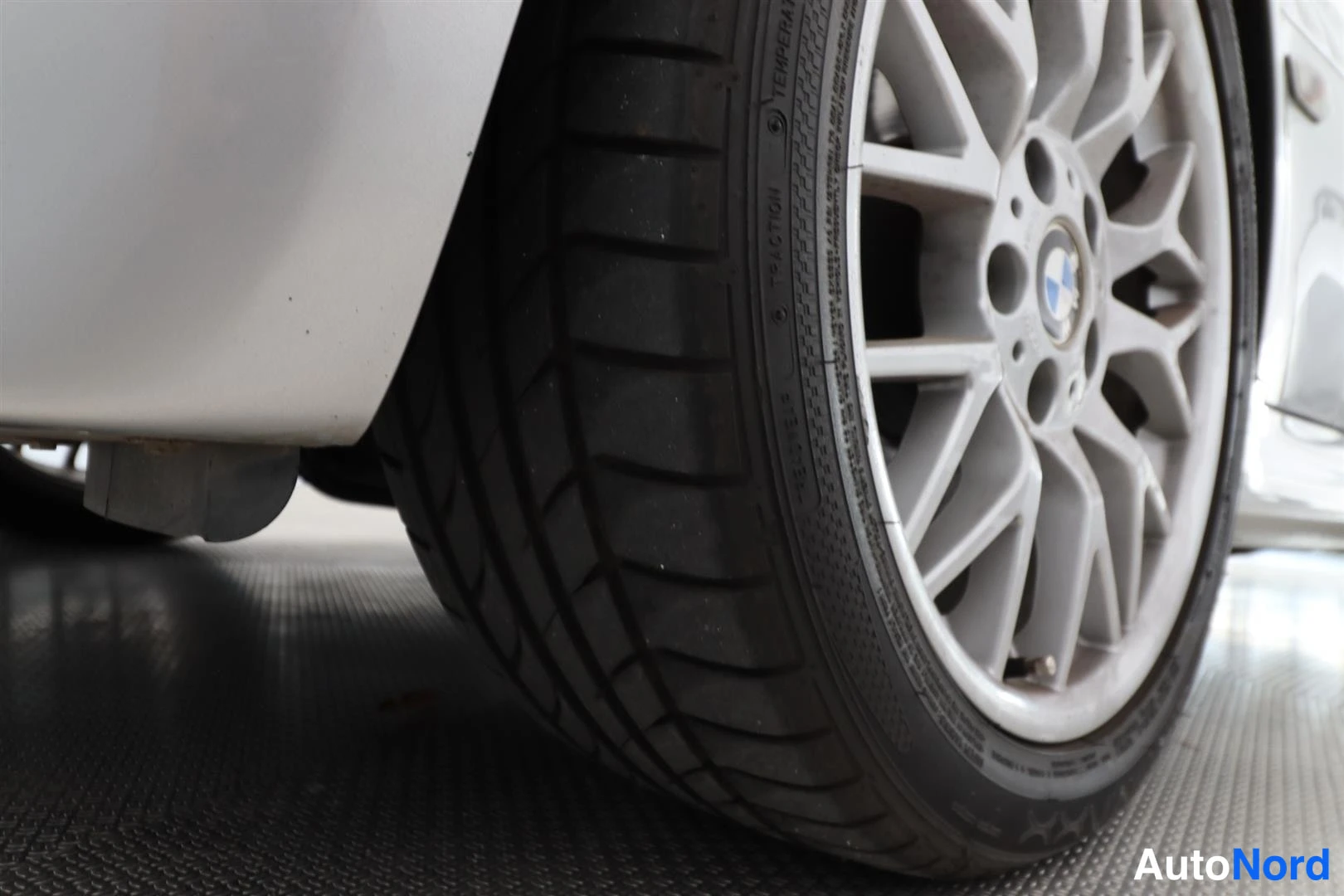 Yksityiskohta: Alumiinvanteen ja renkaan lähikuva BMW-merkki vanteessa.