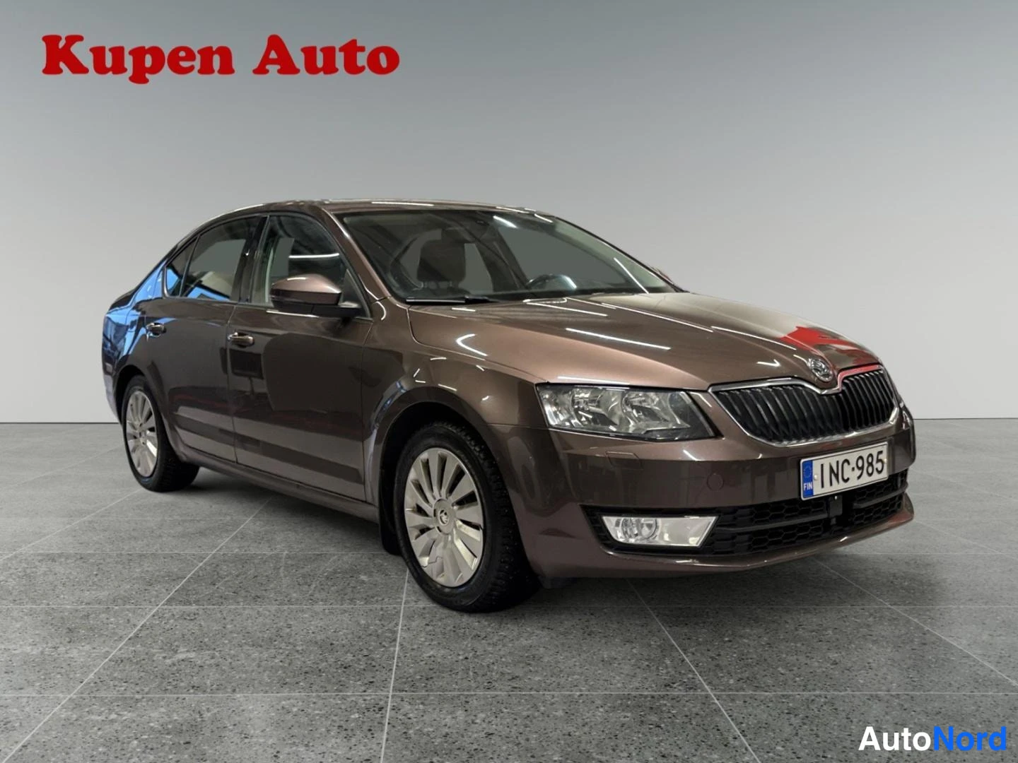 Etuviisto, nokka oikealle: Skoda Octavia -henkilöauto etuosa oikealta, rekisteritunnus, kaksi etuistuinta näkyvien istuimien määrä.