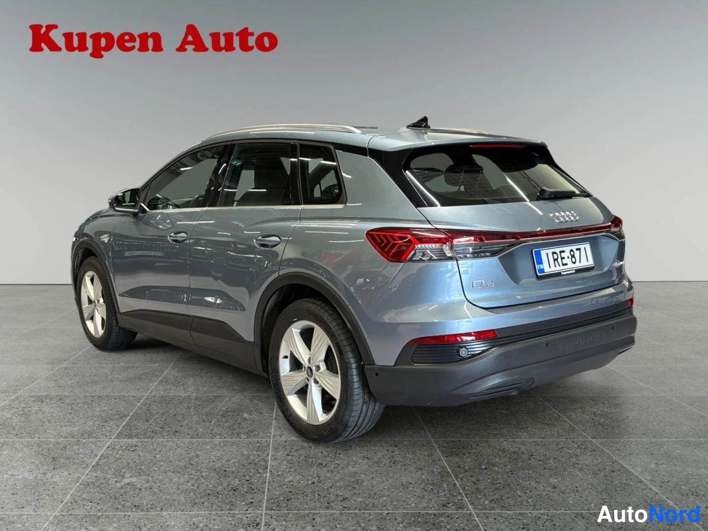 Takaviisto: Sinertävänharmaa Audi Q4 e-tron takaa oikealta kuvattuna, perä ja oikea kylki näkyvissä, rekisterikilpi.