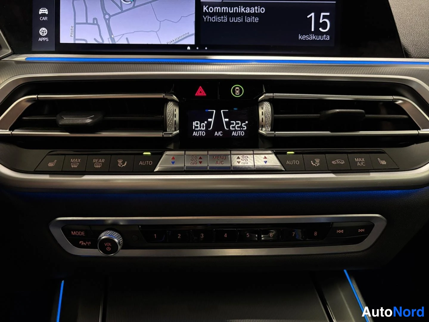 Ohjaamo: Kojelaudan keskiosa: ilmastointipaneeli näyttää 19,0° ja 22,5° AUTO/A.C -tilat, yläpuolella infotainment-näyttö valikolla 'Kommunikaatio – Yhdistä uusi laite' j