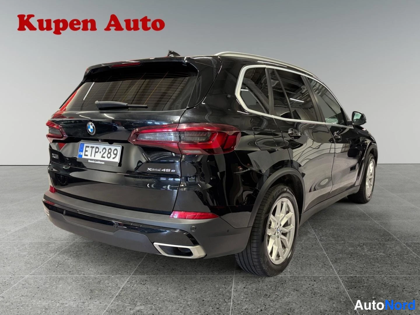 Takaviisto: Musta BMW X5 takaa kulmasta valokuvattuna, XDrive45e-tunnus ja rekisterikilpi näkyvissä.