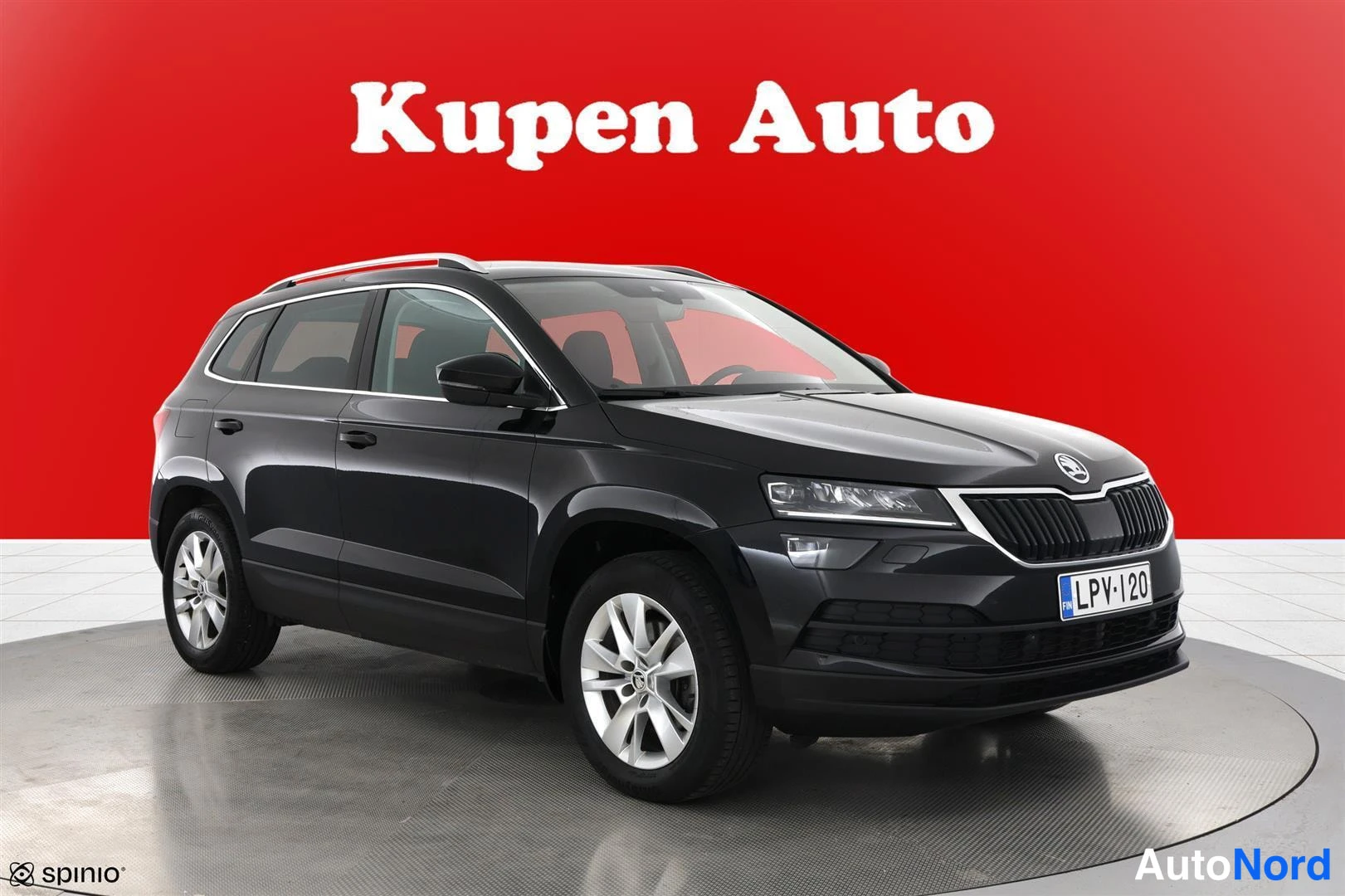 Etuviisto, nokka oikealle: Musta Skoda Karoq -maasturista etukulmakuva oikealta, kylki ja etupää näkyvissä, rekisterikilpi.
