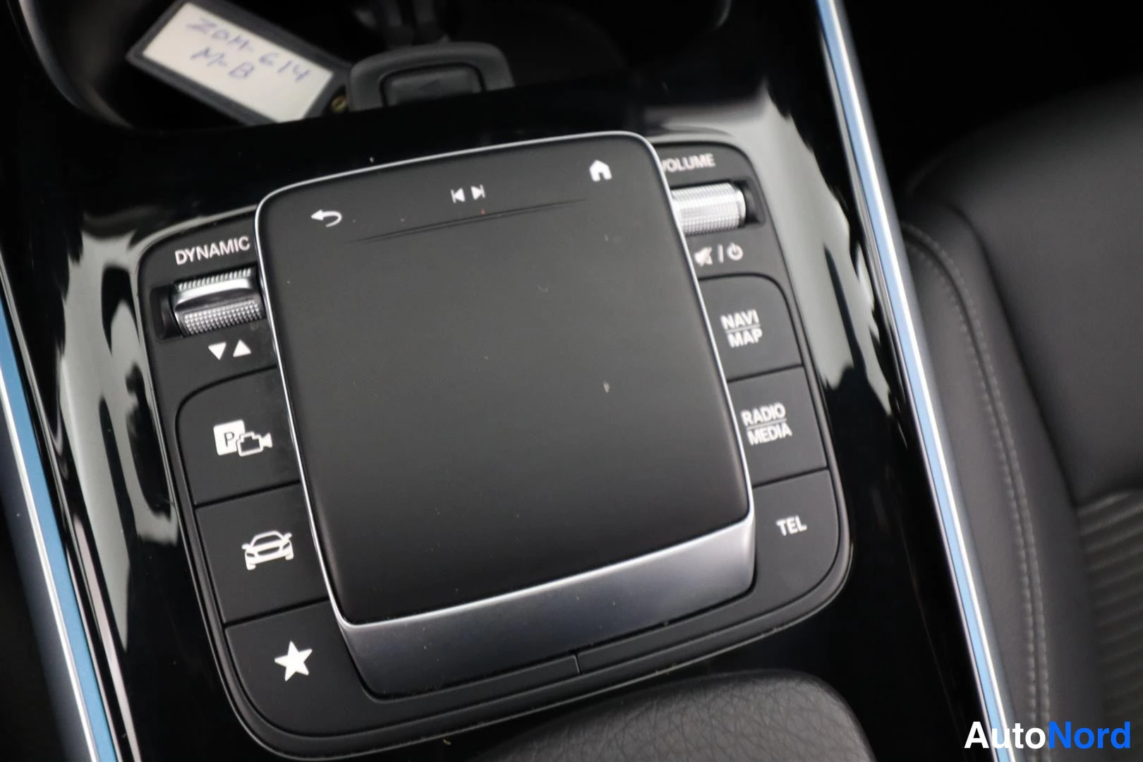 Muu: Mercedes-Benzin keskikonsolin ohjainnäyttö ja painikkeet: DYNAMIC, NAVI MAP, RADIO MEDIA, TEL ja tilavuussäädin.