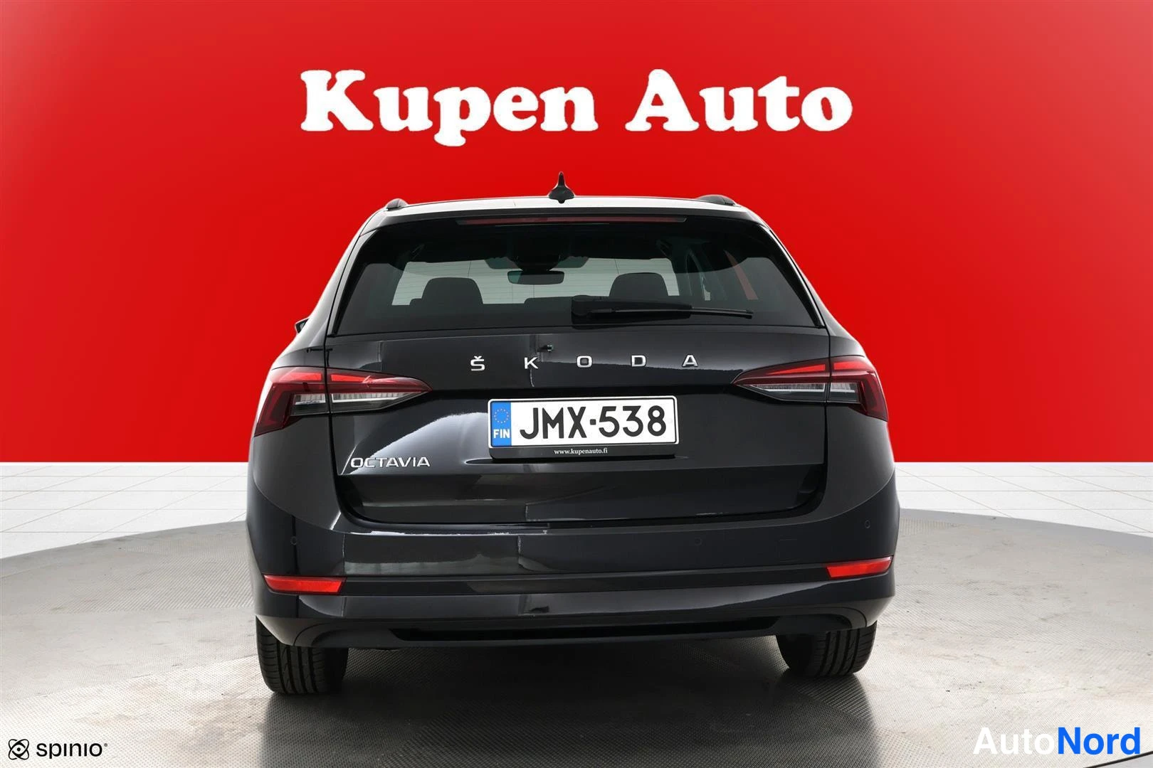 Takaa: Musta farmariauto suoraan takaa, rekisteri, ŠKODA OCTAVIA -merkinnät takaluukussa.