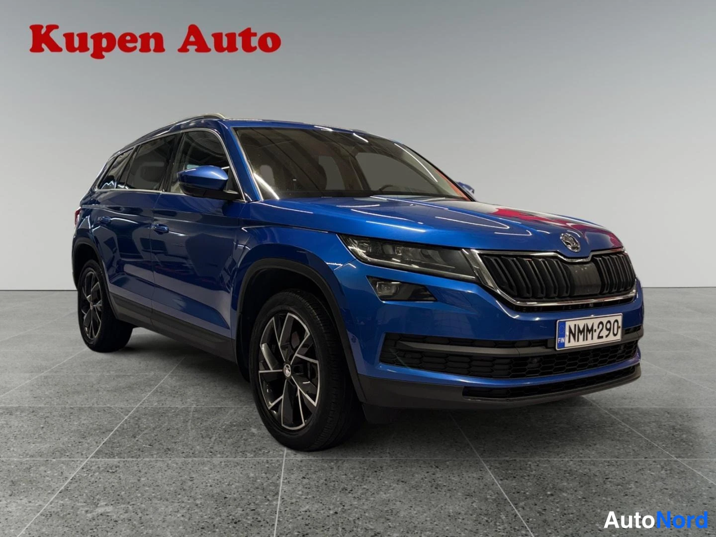 Etuviisto, nokka oikealle: Sininen Skoda Kodiaq etukulmasta vasemmalta oikealle, rekisteritunnus.
