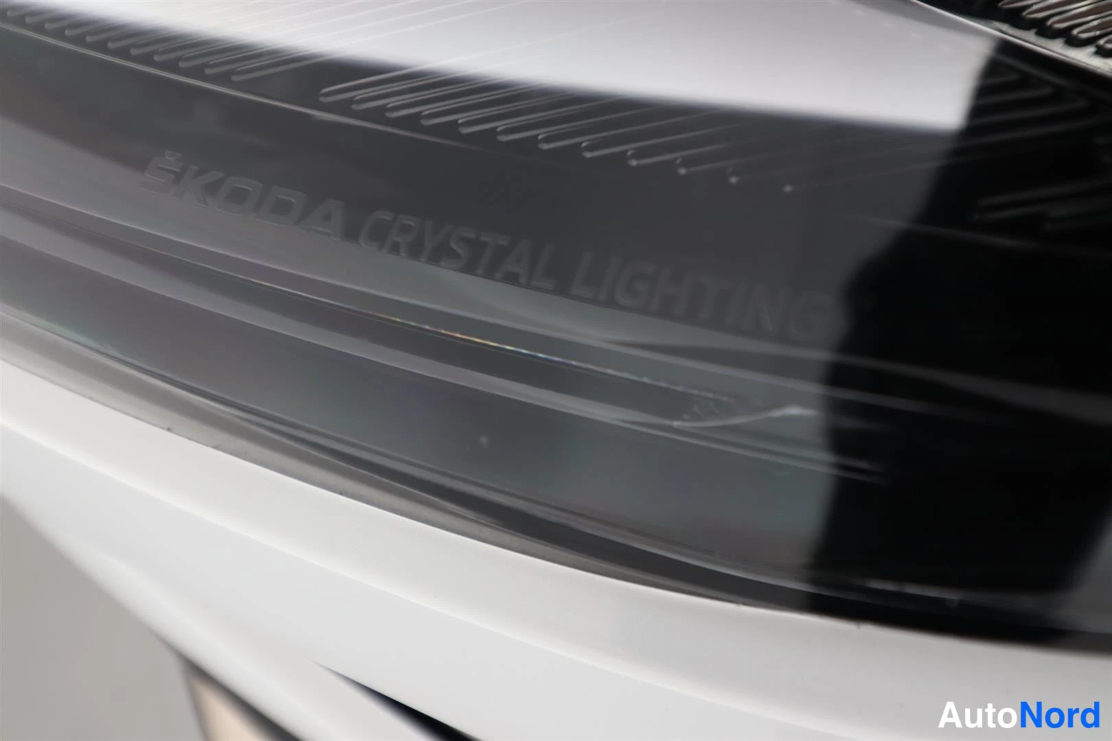 Yksityiskohta: Etusarjen lasin lähikuva, jossa on kaiverrus ŠKODA CRYSTAL LIGHTING.