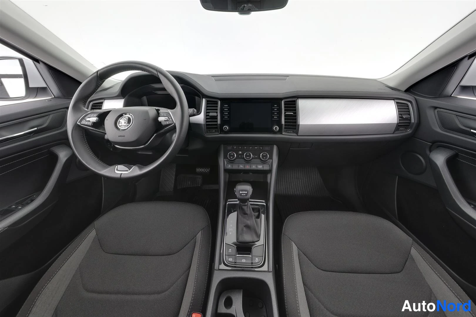 Edestä: Autojen etupenkki ja kojelauta; ohjauspyörä, kosketusnäyttö ja automaattivaihteiston valitsin.