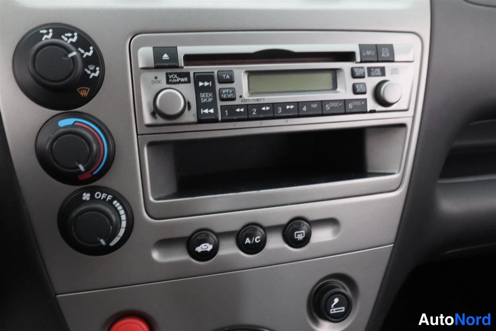 Muu: Kojelaudan keskiosa: CD-radio näytöllä ja numeronäppäimillä, lämmitysnupit, A/C-nappi ja tupakansytytin hopeanharmaassa paneelissa.