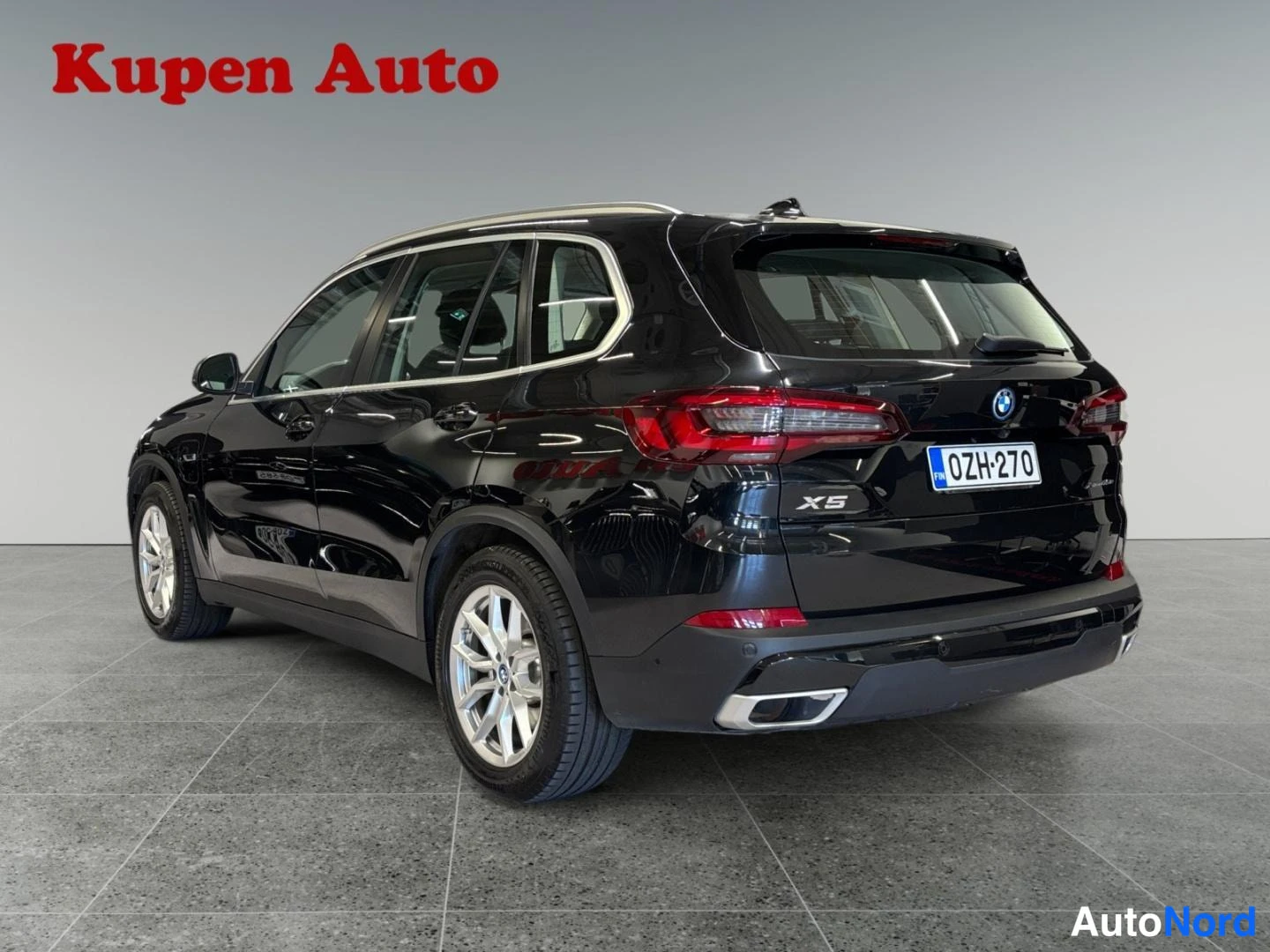 Takaviisto: Mustan BMW X5:n takakulma vasemmalta, rekisterikilpi, studiossa.