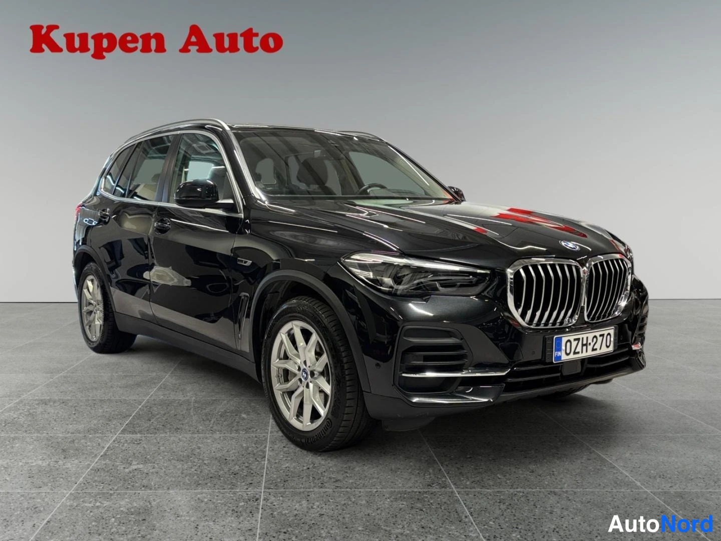 Etuviisto, nokka oikealle: Mustan BMW X5:n etukulma oikealta, rekisterikilpi, studiossa.