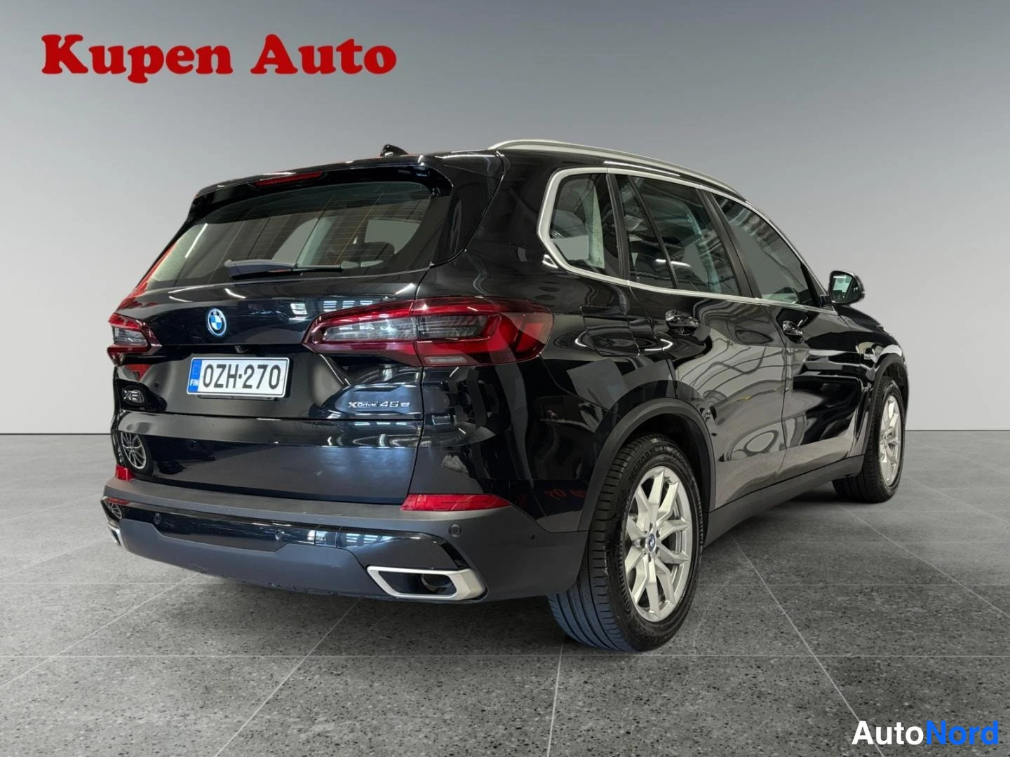 Takaviisto: Mustan BMW X5:n takakulma oikealta, rekisterikilpi, studiossa.