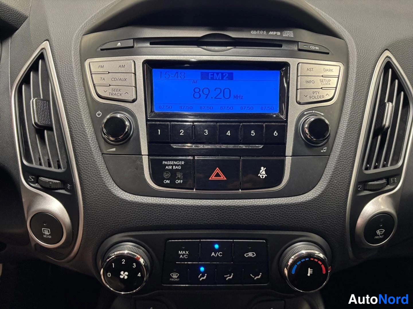 Muu: Kojelaudan keskusyksikkö: radio näyttää kanavaa FM2 89,20 MHz, alla CD/MP3-asema ja äänensäätimet, istuinten lämmitys ja ilmastoinnin A/C- ja MAX A/C -painikkee