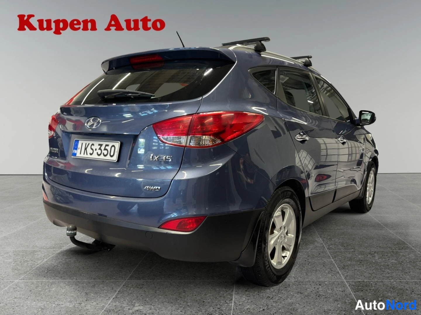 Takaviisto: Hyundai ix35 -maasturin takakulmanäkyvät kattotankineen, rekisterikilpi.