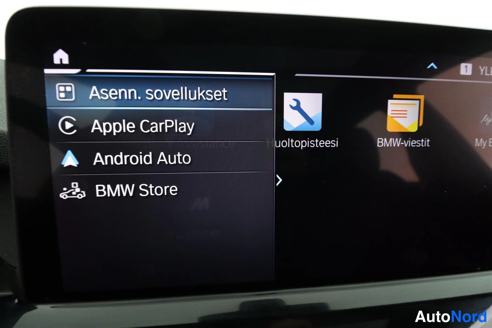 Yksityiskohta: Auton infotainment-näytön valikko: vaihtoehtoina Asenn. sovellukset, Apple CarPlay, Android Auto ja BMW Store.
