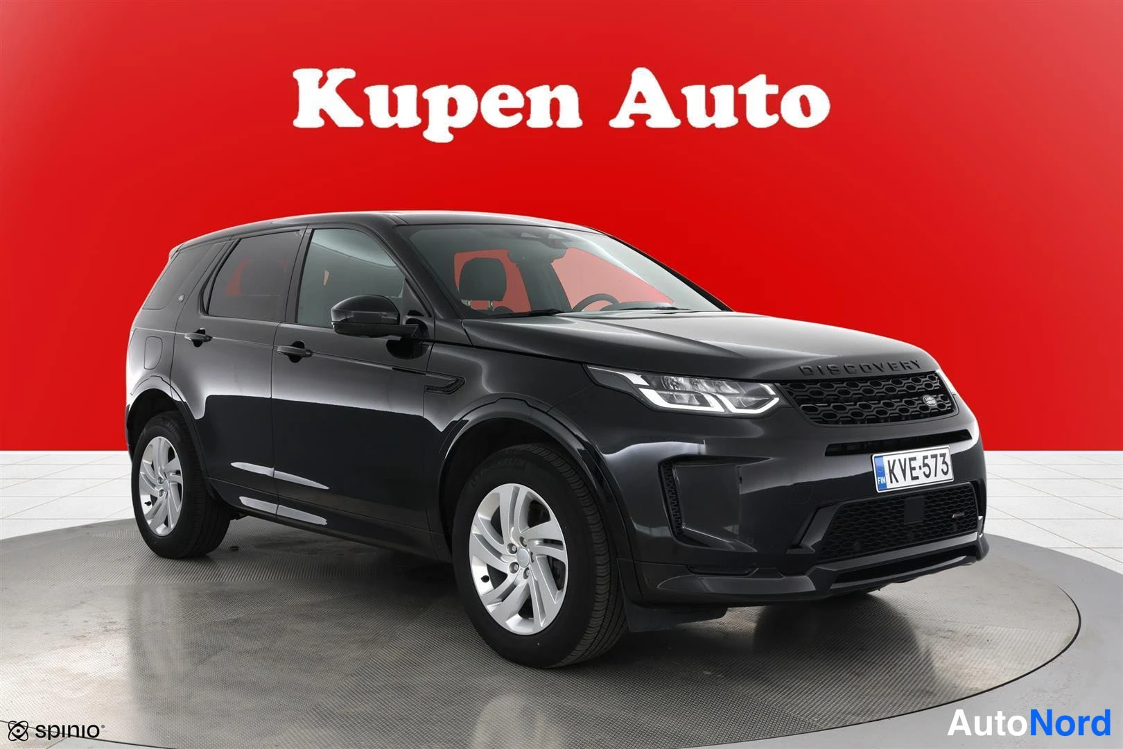 Etuviisto, nokka oikealle: Land Rover Discovery Sport musta, etukolmavelvaus vasemmalta; kylki ja keulapää näkyvissä, rekisteritunnus.