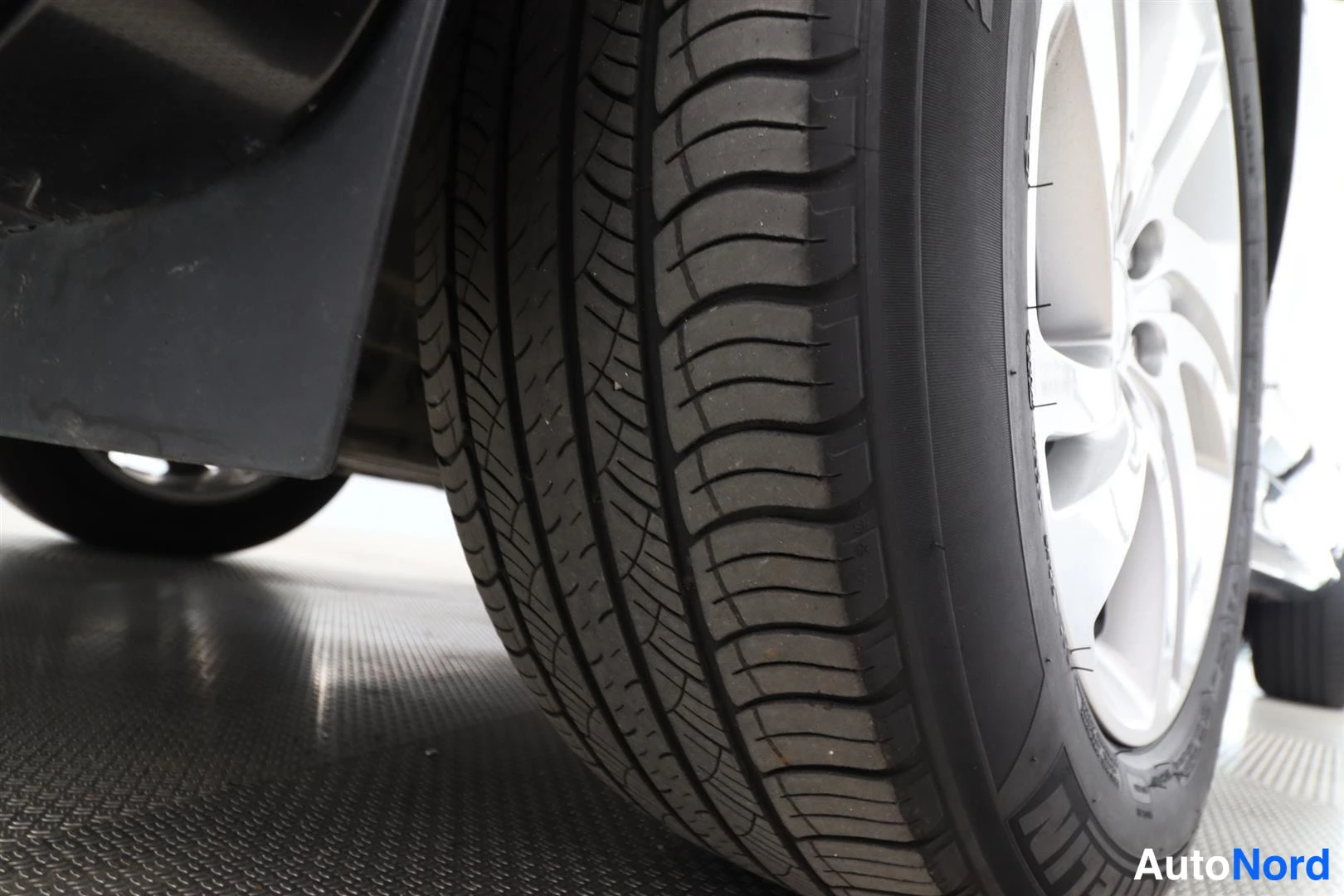 Muu: Mustan rungon etupyörän läheiskuva: hopeavanne ja Michelin-kesärenkaat, hyvä nastoitus, musta mökki vasemmalla.