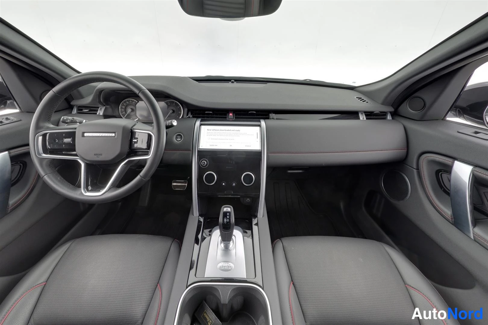 Muu: Land Rover Discovery Sportin etupenkki ja kojelauta mustalla nahkapinnalla ja punaisilla ompeleilla, kosketusnäyttö ja automaattivaihteen valitsin.