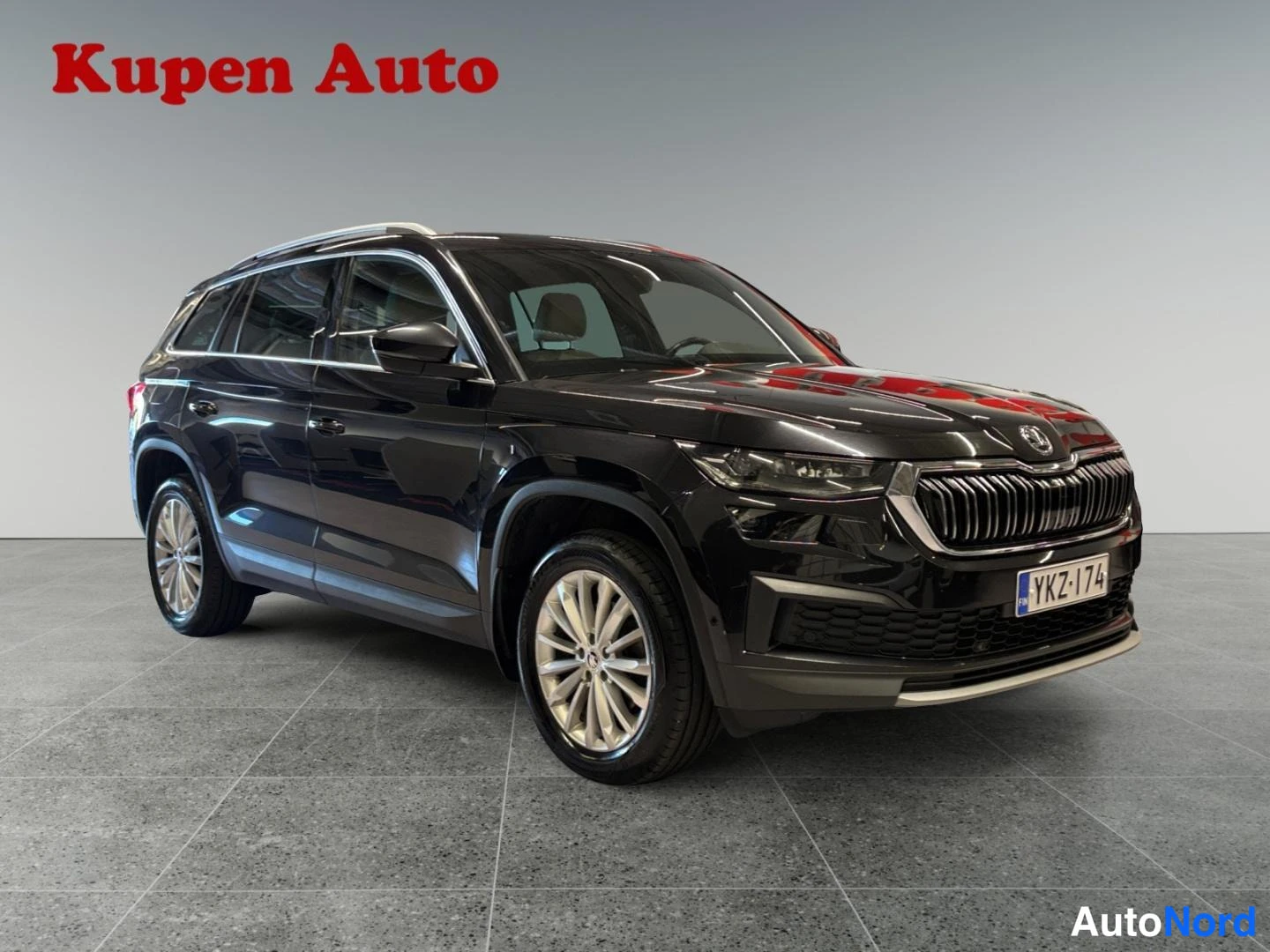 Etuviisto, nokka oikealle: Musta Skoda Kodiaq kuvattu etukulmasta oikealta sisätiloissa, rekisteritunnus.