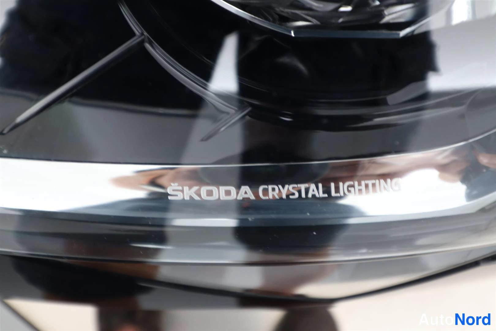 Yksityiskohta: Etutulostimen lähikuva, jossa teksti ŠKODA CRYSTAL LIGHTING.