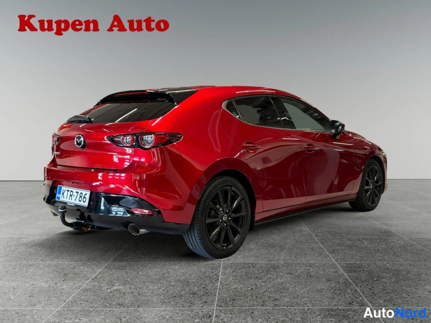 Takaviisto: Punaisen Mazda 3:n takaosa ja vasen kylki, rekisteritunnus, mustat vanteet.