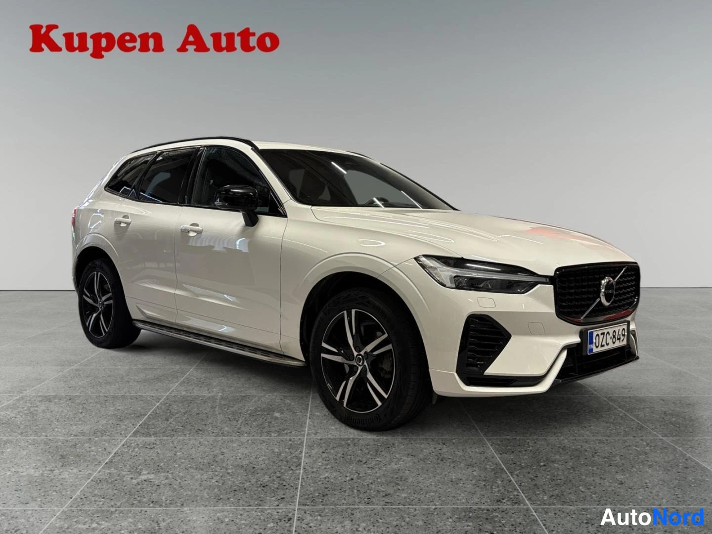 Etuviisto, nokka oikealle: Ulkomitat: valkoinen Volvo XC60 -tyyppinen SUV kuvattu kolmivarta edestä oikealta studiossa.