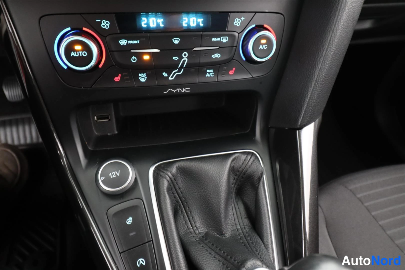 Yksityiskohta: Keskikonsoli: kaksivyöhykeilmastointi (AUTO, A/C), SYNC-merkintä, USB-portti, 12V-pistorasia ja vaihteenkehiö.