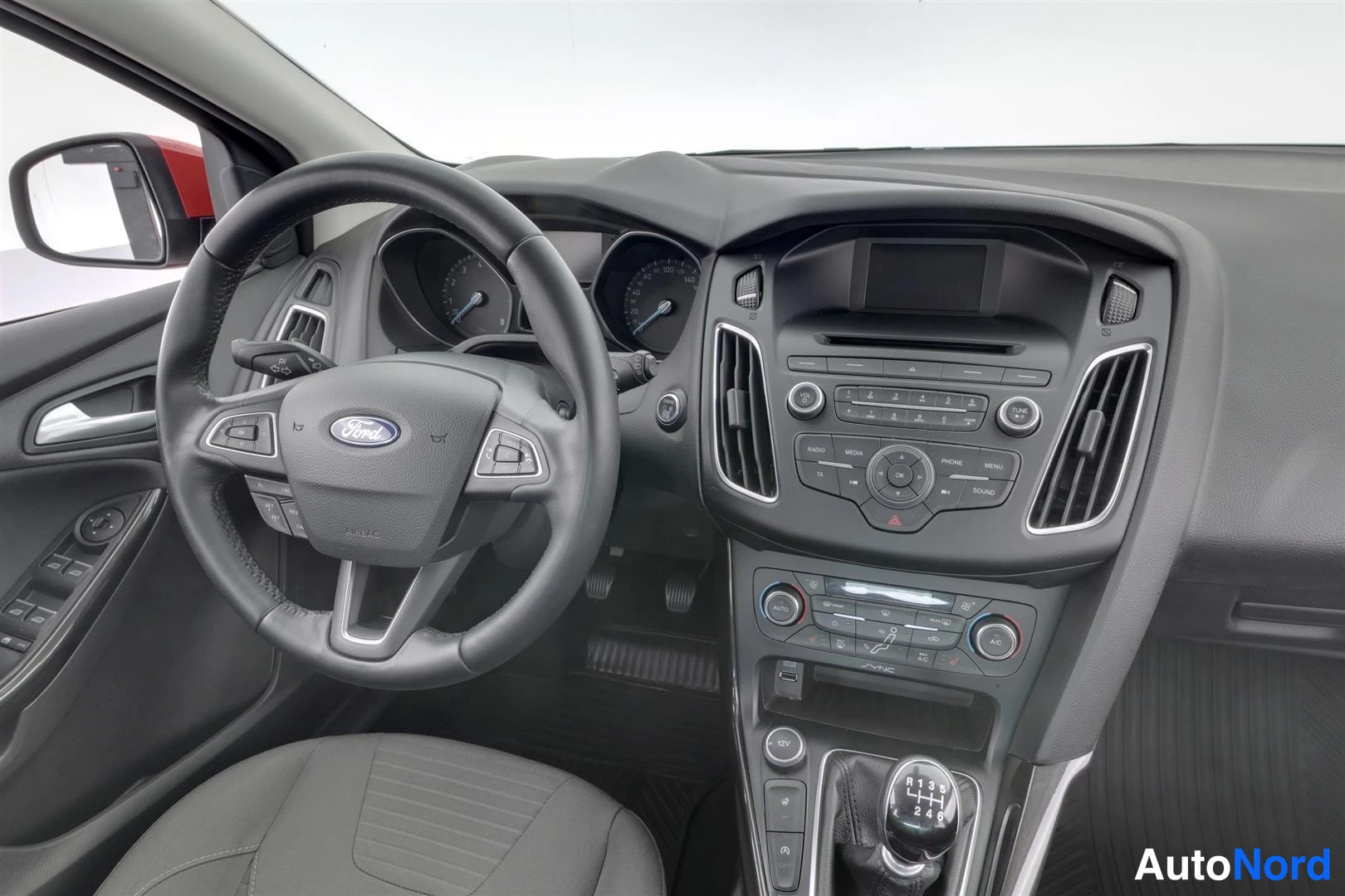 Muu: Ford Focusin ohjaamo lähikuvassa: Ford-merkkinen ohjauspyörä, mittaristo, äänijärjestelmä ja 1–3–5/R-vaihteinen manuaalivaihdin.