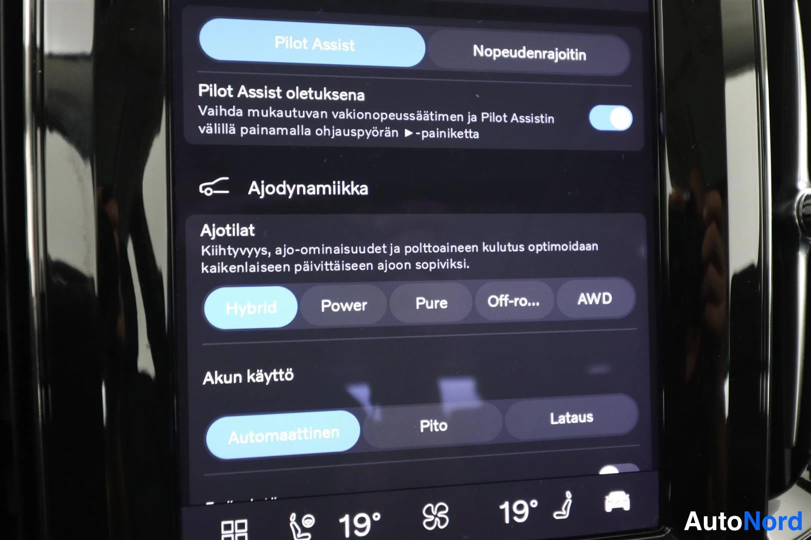 Yksityiskohta: Auton kosketusnäytön asetusnäkymä, jossa valittuna Pilot Assist ja Hybrid-ajotila sekä akun käytön Automaattinen-valinta.