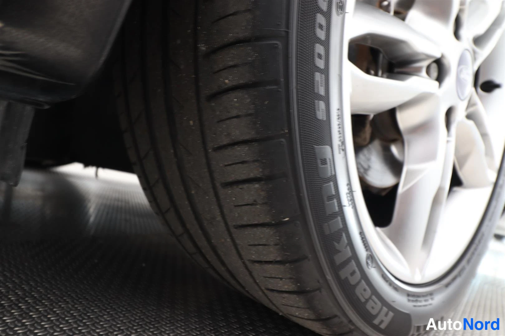 Yksityiskohta: Lähikuva auton renkaasta, jossa lukee Goodyear Eagle, alumiinivannelle osin näkyvissä.