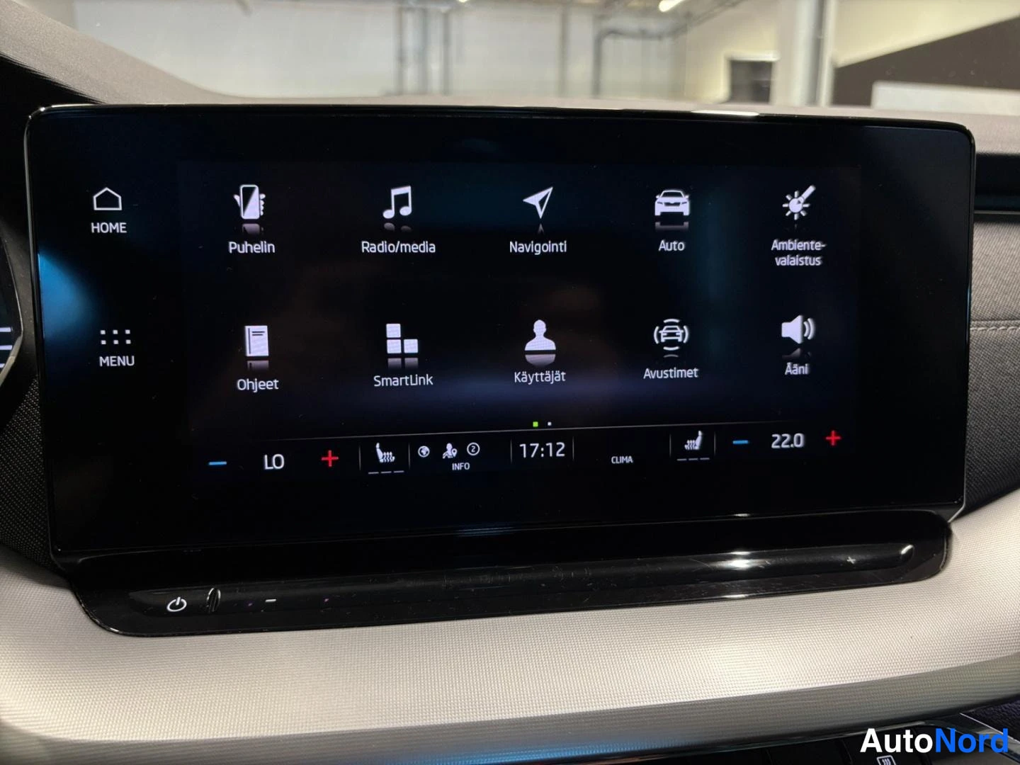 Yksityiskohta: Infotainment-näytön päävalikko kuvakkeilla: Puhelin, Radio/media, Navigointi, Auto, Ambiente-valaistus, Ohjeet, SmartLink, Käyttäjät, Avustimet ja Ääni.
