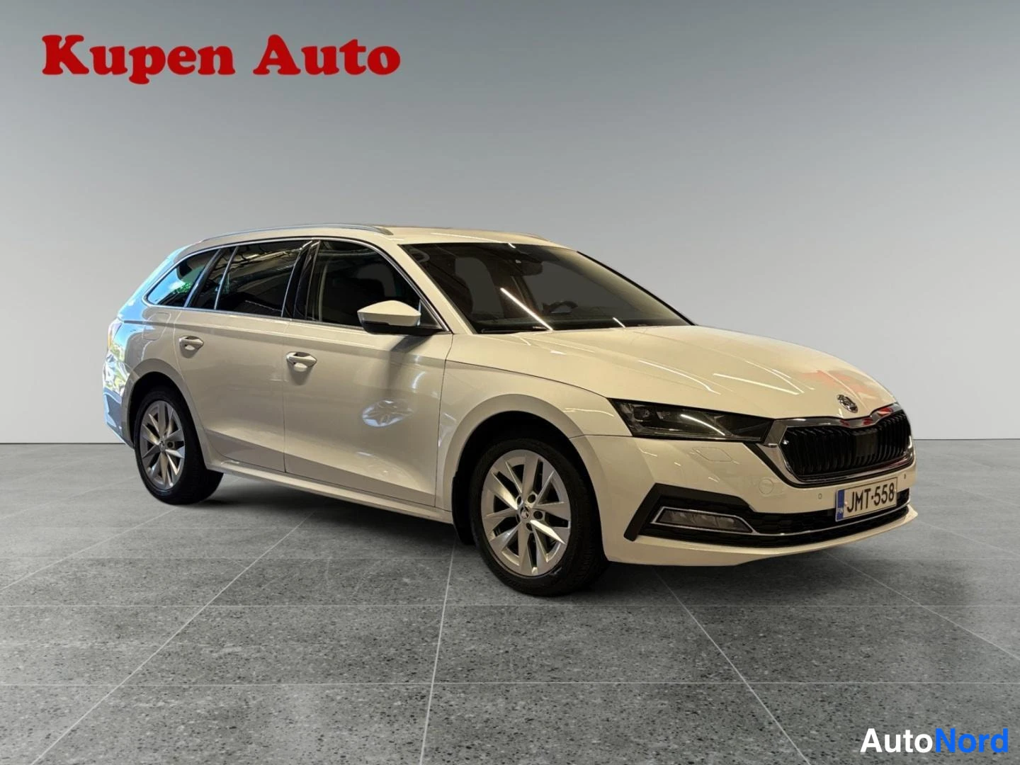 Etuviisto, nokka oikealle: Skoda Octavia -farmari etukolmasosakulma kuvattuna oikealta, vaalea kori ja maski näkyvät studiotilassa.