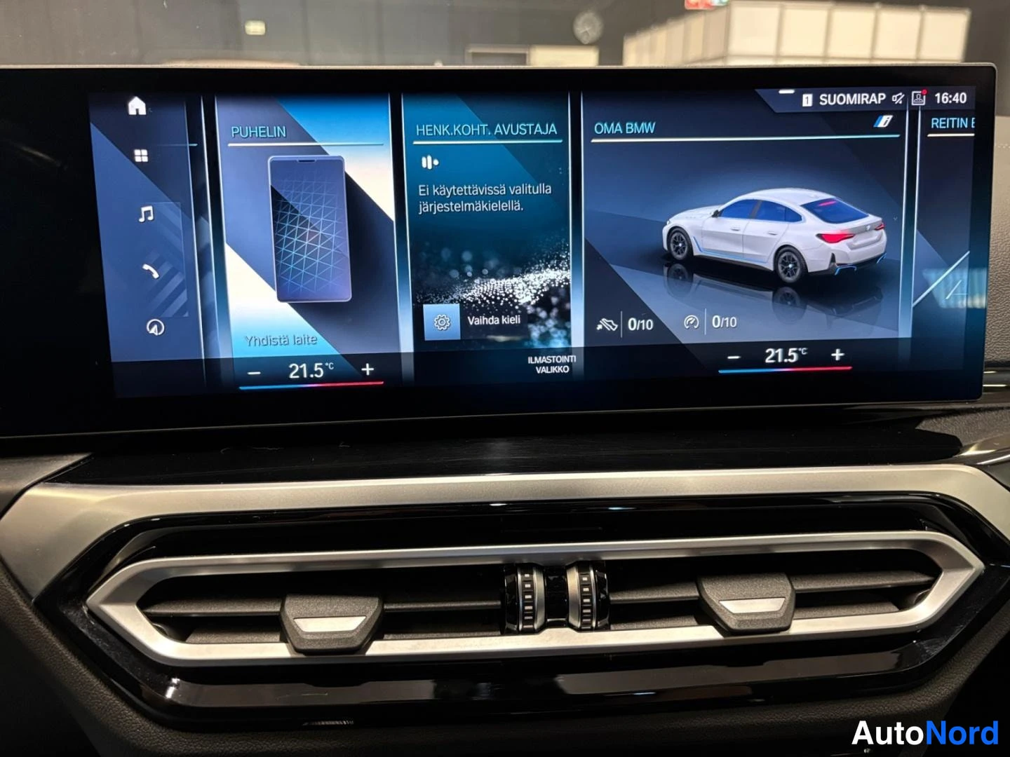 Muu: Auton keskinäytös näyttää puhelin-, henkilökohtaisen avustajan ja Oma BMW -ruudut valkoisella autonkuvalla; ilmastointi 21,5 astetta.