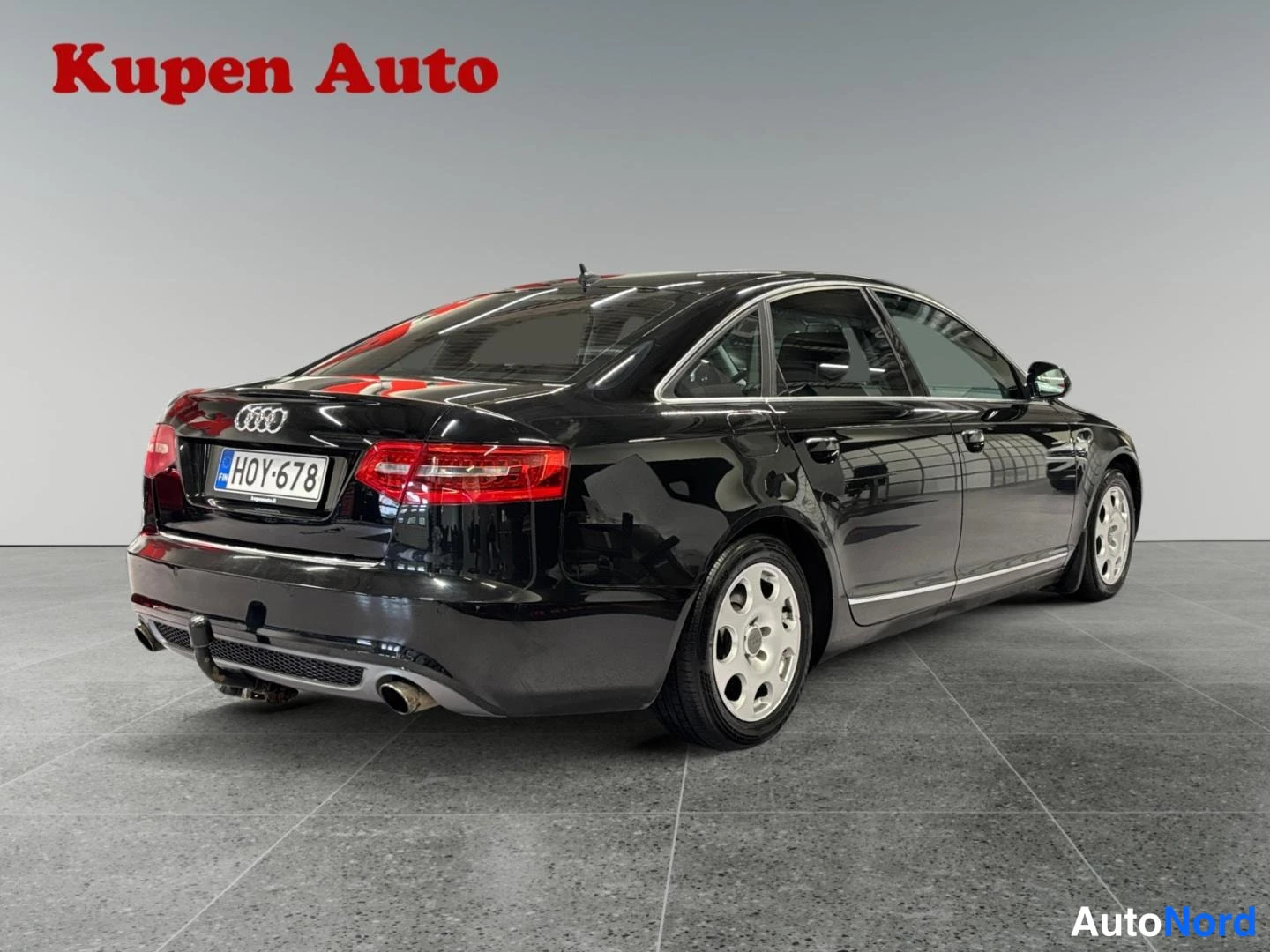 Takaviisto: Mustan Audi A6 -sedanin täkulmatkuva oikealta, rekisteritunnus.