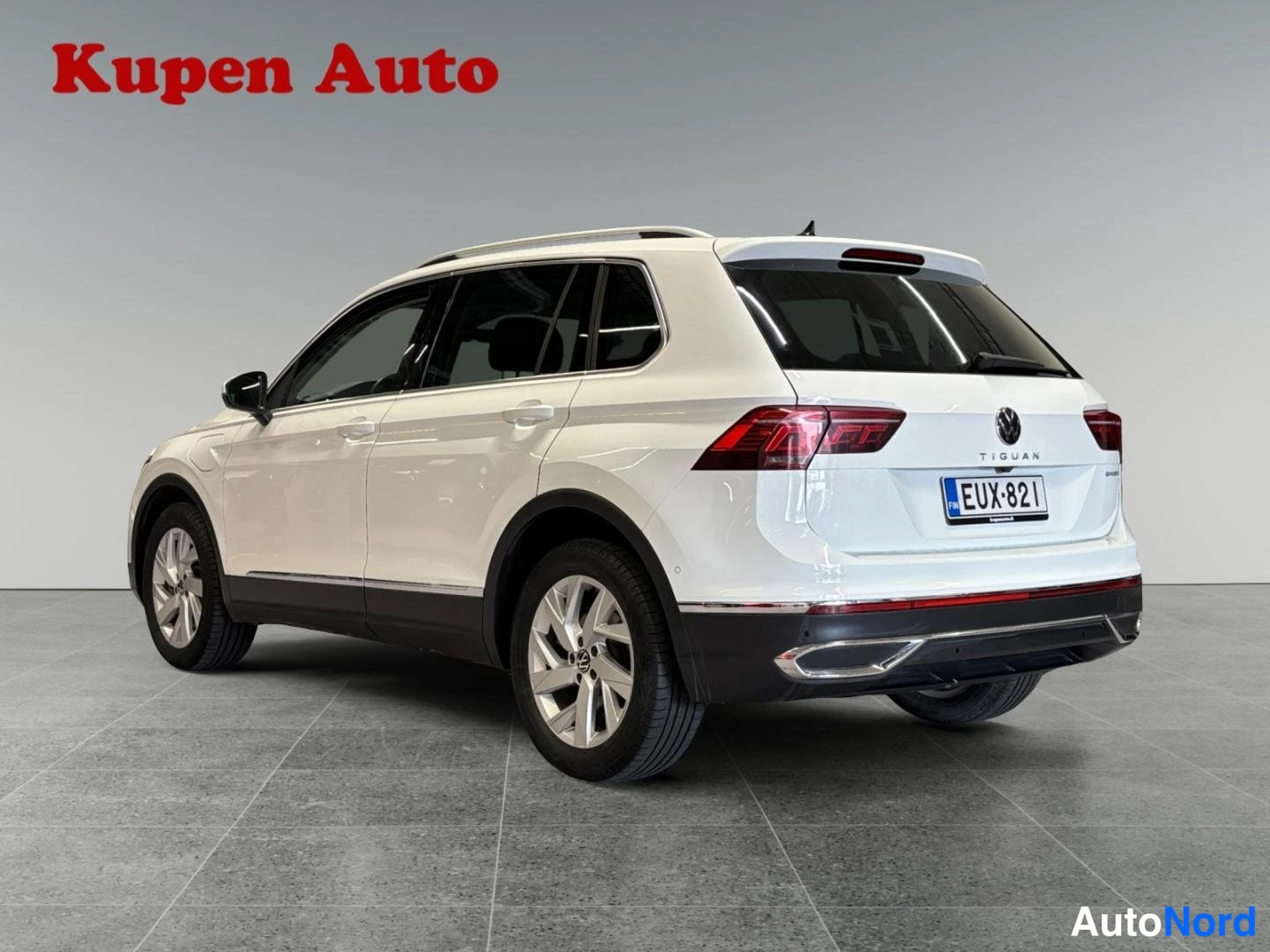 Takaviisto: Valkoinen Volkswagen Tiguan kuvattu takakulmasta oikealta, rekisteritunnus, perän TIGUAN-teksti näkyy.
