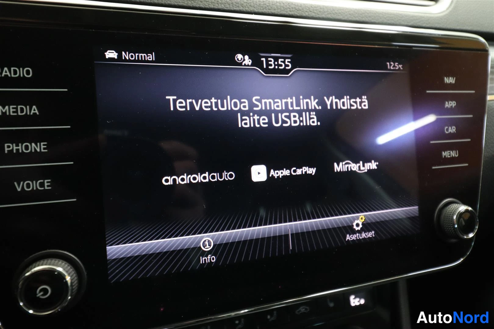 Yksityiskohta: Auton kojelaudan infotainment-näyttö, jossa lukee Tervetuloa SmartLink. Yhdistä laite USB:llä ja näkyy Android Auto-, Apple CarPlay- ja MirrorLink-logo.